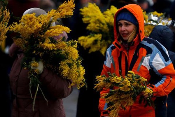 امرأة تحمل باقات من الزهور للبيع قبل اليوم العالمي للمرأة في سوق الزهور بموسكو، روسيا في 7 مارس، 2018. Getty ImagesSefa Karacan/Anadolu Agency